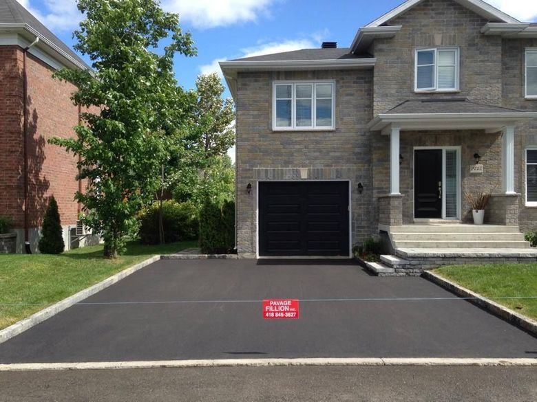 Entrée asphaltée devant une luxueuse maison en brique