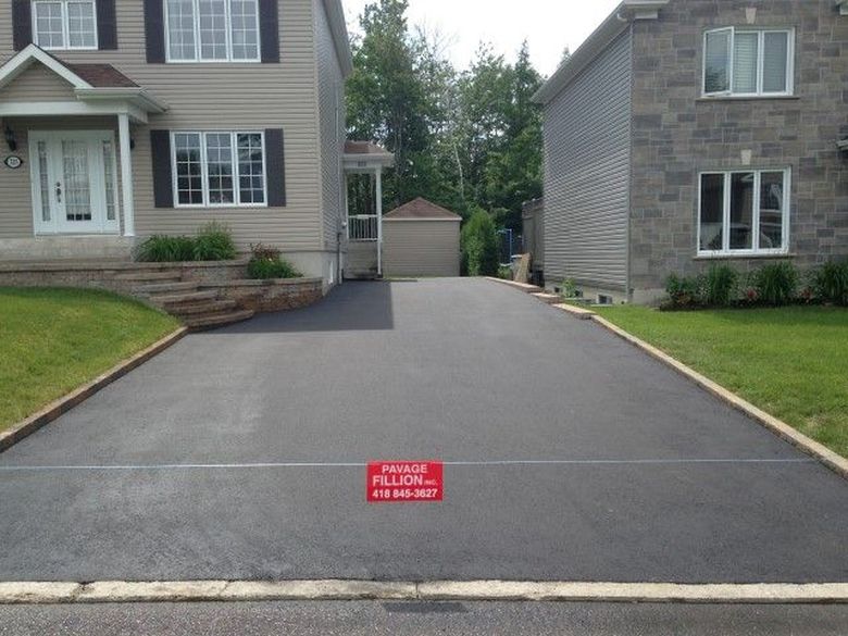 Grande entrée pavée sur le côté d'une maison beige